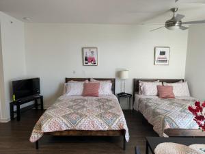 Un dormitorio con dos camas y un televisor de pantalla plana. en Incredible Hollywood Loft Free Parking, en Los Ángeles
