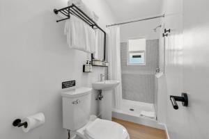 a white bathroom with a toilet and a sink at Aliza Hotel in Los Angeles