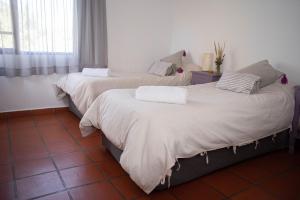 2 camas individuales en una habitación con ventana en Loma Puskana - Casas en Cachí