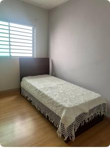 a bedroom with a bed in a room with a window at Casa aconchegante no centro in Divinópolis