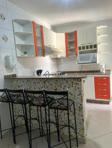 a kitchen with two chairs and a counter top at Casa aconchegante no centro in Divinópolis