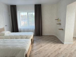 een hotelkamer met 2 bedden en een raam bij Apartments in Pyrogovo in Vinnytsya