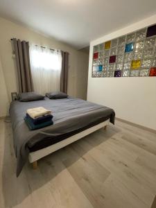 um quarto com uma cama com um quadro na parede em Charmante Maison 3 Chambres Plein Centre avec Parking Privé Gratuit em Lorient