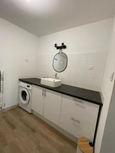 łazienka z umywalką i pralką w obiekcie Charmante Maison 3 Chambres Plein Centre avec Parking Privé Gratuit w mieście Lorient