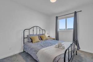 a bedroom with a bed and a window at LovelyHome-Foosball-NearAirport-5 Queen Beds -Air conditioning in Edmonton