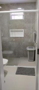 uma casa de banho com uma cabina de duche em vidro e um WC. em Recanto Munik em Palhoça