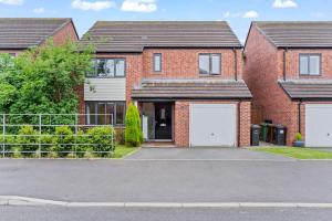 a brick house with two white garage doors at Luxury Modern House - 8 mins to NEC, Airport in Birmingham