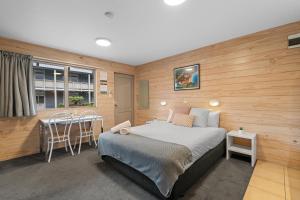 a bedroom with a bed and a table and chairs at Tasman Holiday Parks - Christchurch in Christchurch