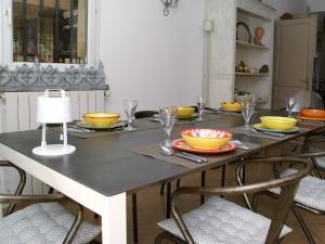 a dining room table with bowls and plates on it at Le Cezanne in Aix-en-Provence