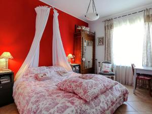 a bedroom with a bed with a red wall at Le Cezanne in Aix-en-Provence
