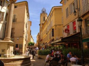 a group of people sitting at tables in a street at Le Cezanne in Aix-en-Provence