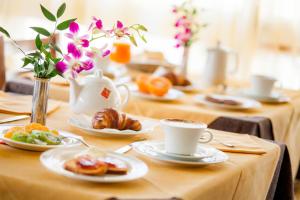 einen Tisch mit Teller mit Speisen und Tassen Kaffee in der Unterkunft Hotel Candido in Diano Marina
