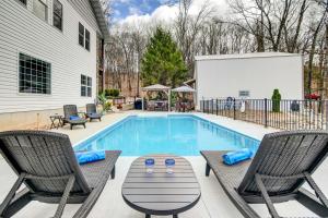 a swimming pool with chairs and a white house at Secluded Branson Escape with Pool and Game Room! in Branson