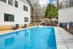 a swimming pool in front of a house at Secluded Branson Escape with Pool and Game Room! in Branson