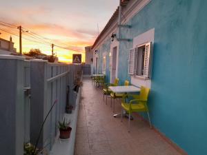 un patio con mesas y sillas en el lateral de un edificio en Ibiza Suite Independent bedroom and bathroom, en Albufeira
