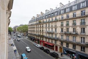 a city street with cars parked in front of buildings at Luxury Parisian Apartment NOTRE DAME SAINT GERMAIN DES PRES in Paris