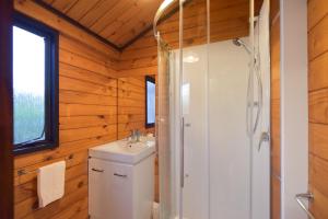 y baño con lavabo blanco y ducha. en Cooper's Lakeside Cabin, en Rotorua