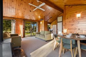 a living room with a table and chairs at Cooper's Lakeside Cabin in Rotorua