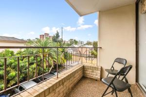 2 sedie su un balcone con vista sugli alberi di Large 1-Bed with Swimming Pool in Iconic Bondi a Sydney