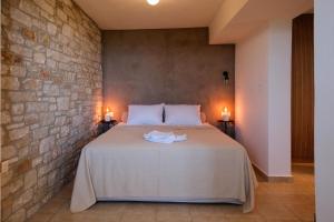 a bed in a room with a brick wall at Hideaway in Damouchari with private access to sea ANNA's HORIZON in Damouchari