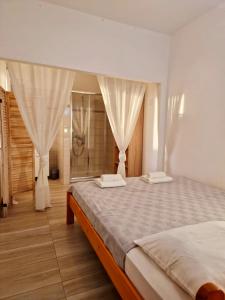 a bedroom with a large bed with white curtains at Hestia Apartments in Rovinj +58 photos
