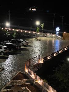 a flooded parking lot at night with cars parked at Oda N'Bjeshke in Valbonë