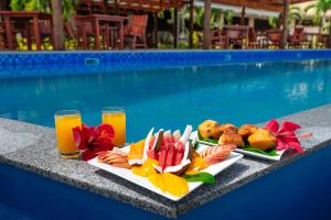 una bandeja de comida y bebida junto a la piscina en Aitutaki Lagoon Private Island Resort (Adults Only), en Arutanga