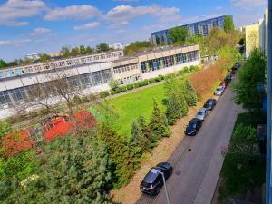 eine Reihe von Autos, die vor einem Gebäude geparkt sind in der Unterkunft Apple Apartments - Atlas Arena, Zoo, Fala, Mandoria, lotnisko, parking in Łódź