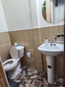 La salle de bains est pourvue de toilettes et d'un lavabo. dans l'établissement Gywel, à San Salvador