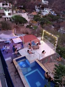 a group of people sitting around a swimming pool at Tayrona Colors Hostel in Taganga