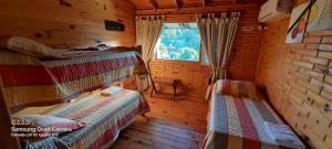 Habitación con 2 camas en una cabaña de madera en CABAÑA LA MATILDE en Río Ceballos