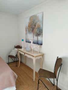 een slaapkamer met een bureau en een schilderij aan de muur bij Maison La Thébaïde in Castéra-Lectourois