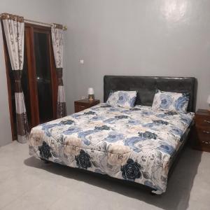a bedroom with a bed with a blue and white comforter at The Balbina House in Labuan Bajo