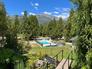 un jardín con piscina y árboles en CABANAS ´PORTAL NORTE en El Bolsón