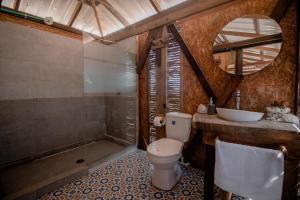 a bathroom with a toilet and a sink at Watu Kite House in Mayapo +89 photos