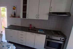 a kitchen with white cabinets and a sink and a stove at Apartments with parking space Gajac, Pag - 22921 in Novalja