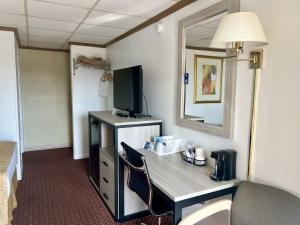 a hotel room with a desk with a tv and a room at Travelodge by Wyndham Hershey in Hershey