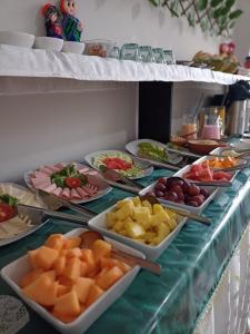 - un buffet avec de nombreuses assiettes de fruits sur une table dans l'établissement Ayma Hostel Puno, à Puno