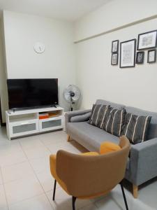 a living room with a couch and a tv at Asteria Lovely Staycation in Manila