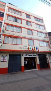Ayma Hostel Puno في بونو: مبنى ابيض كبير باللونين الاحمر والابيض