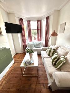a living room with a couch and a coffee table at Charming, Renovated Residence in Willesden Green in London