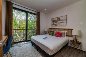 a bedroom with a bed and a large window at CHIC 3-Levels at MUN - Rooftop Deck - Pool in Tulum