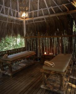 a room with two benches and a thatched roof at El Bosque Hotel Boutique in Doradal