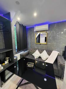 a living room with a couch and a mirror at Room & Jacuzzi - Stade de France in Saint-Denis