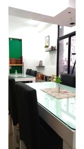 Aparta Hotel في بوينس آيرس: غرفة طعام مع طاولة وكراسي زجاجية