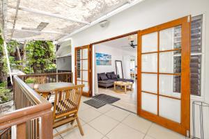 Un balcón con una puerta que conduce a una sala de estar. en Palm Cove Beach Retreat - 1st Floor en Palm Cove