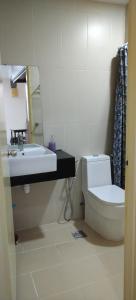 y baño con aseo blanco y lavamanos. en Swiss Garden Resort Residence, studio, sea & pool view, high level unit, en Kuantan
