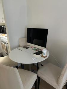 Cosy Living: Your Private Urban Retreat في فانكوفر: وجود جهاز كمبيوتر جالس على طاولة بيضاء مع كرسيين