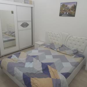 een slaapkamer met een bed en 2 spiegels bij URBAN 1 Ferizaj City in Ferizaj