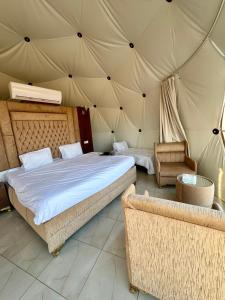 a bedroom with a bed and a couch in a tent at Jabal Rum Camp in Wadi Rum